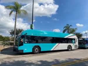 Image of the new Palm Tran buses with a teal block and stripes
